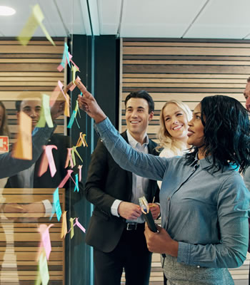 people gathered in front of post it note board