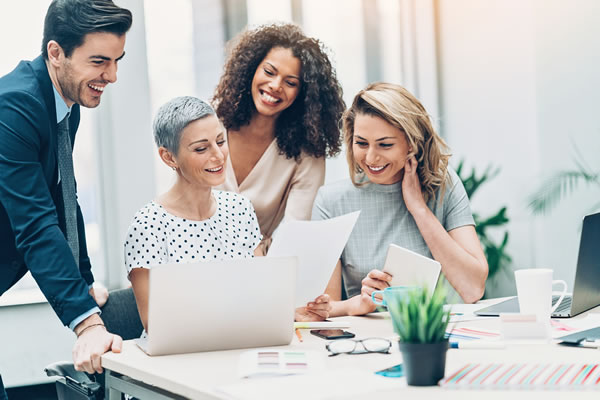 group of people smiling and looking at piece of paper