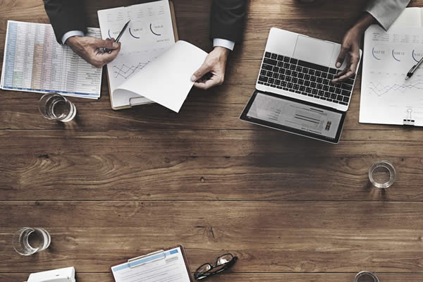 table with business papers and laptop